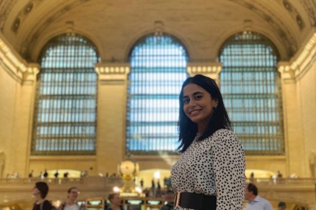 Fatima standing in a brightly lit hall, looking at the camera.