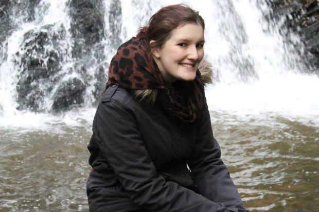 Katie sitting in front of a waterfall.