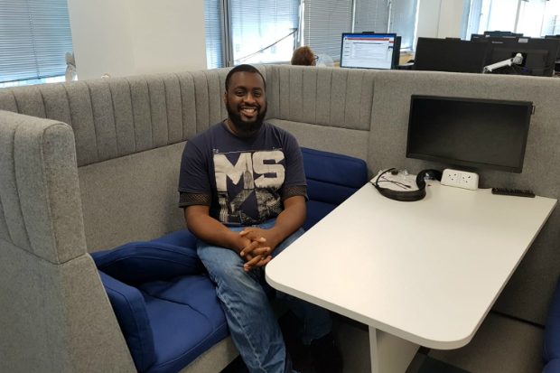 Ahmed sitting in a chair smiling at the camera.