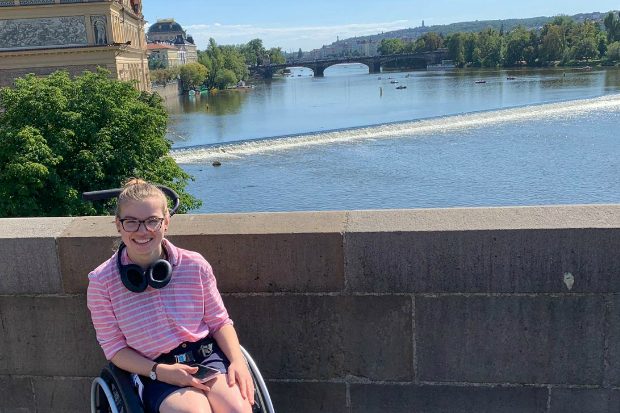 Katherine on a bridge with a river behind her.