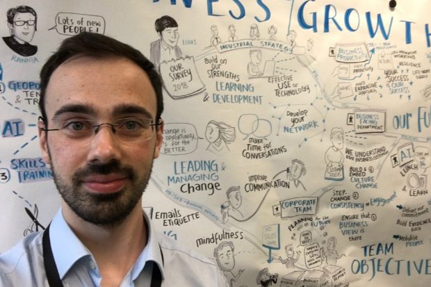 Keith standing in front of a board with lots of writing on.