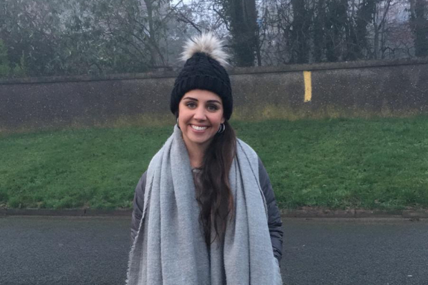 Amelia standing in a park and smiling at the camera.